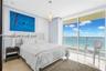 Floor-to-ceiling glass sliding doors, polished tile flooring, recessed ceiling lighting, and a pendant light fixture