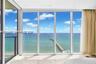 Floor-to-ceiling glass panel walls, recessed ceiling lighting, and polished stone flooring