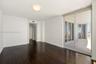 Interior space featuring dark wood-finish flooring, floor-to-ceiling glass sliding doors, and a private balcony with exterior railings