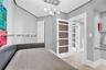 Contemporary interior featuring a multi-light globe chandelier, wood-grain panel doors, glass-paneled interior doors, built-in glass shelving, and neu