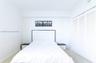 Neutral-toned carpeting, white walls, and a built-in closet with white louvered doors