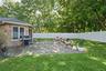 Stone-veneer exterior, paved patio, and white privacy fencing