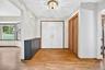Foyer featuring wood-finish flooring, double-door entryway, built-in storage cabinetry, sliding-door closet, and overhead decorative lighting