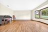 Spacious interior featuring wood-finish flooring, neutral wall tones, and a large bay window configuration