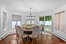 Bay-style dining area featuring wood-finish flooring, crown molding, recessed lighting, an architectural metal chandelier, and sliding glass doors