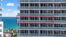 High-rise balcony featuring floor-to-ceiling glass doors and a glass panel railing