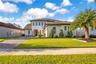 Beautiful two-story exterior featuring a paver driveway, manicured lawn and upgraded landscaping.