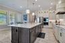 Designer kitchen with stacked cabinetry, illuminated upper display cabinets and built-in stainless steel appliances.