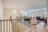 Open upstairs landing with upgraded stair railings leads into a spacious loft.
