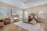 Spacious master featuring hardwood flooring, plantation shutters and abundant natural light, with room for a sitting area.