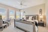 Inviting bedroom featuring plush carpet, plantation shutters and a ceiling fan.