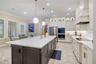 Beautifully appointed kitchen featuring a decorative backsplash, statement range hood and abundant cabinet storage.