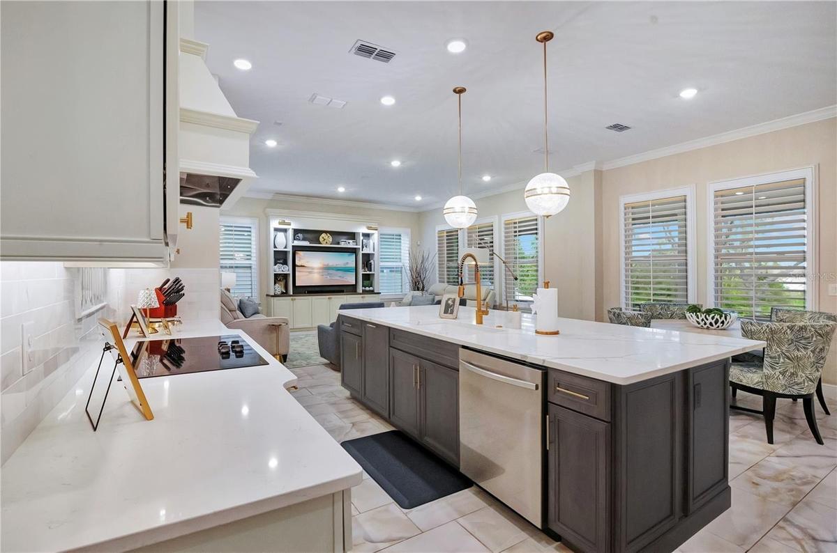 Expansive kitchen island features an undermount sink, built-in dishwasher and generous preparation space.