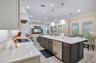 Expansive kitchen island features an undermount sink, built-in dishwasher and generous preparation space.