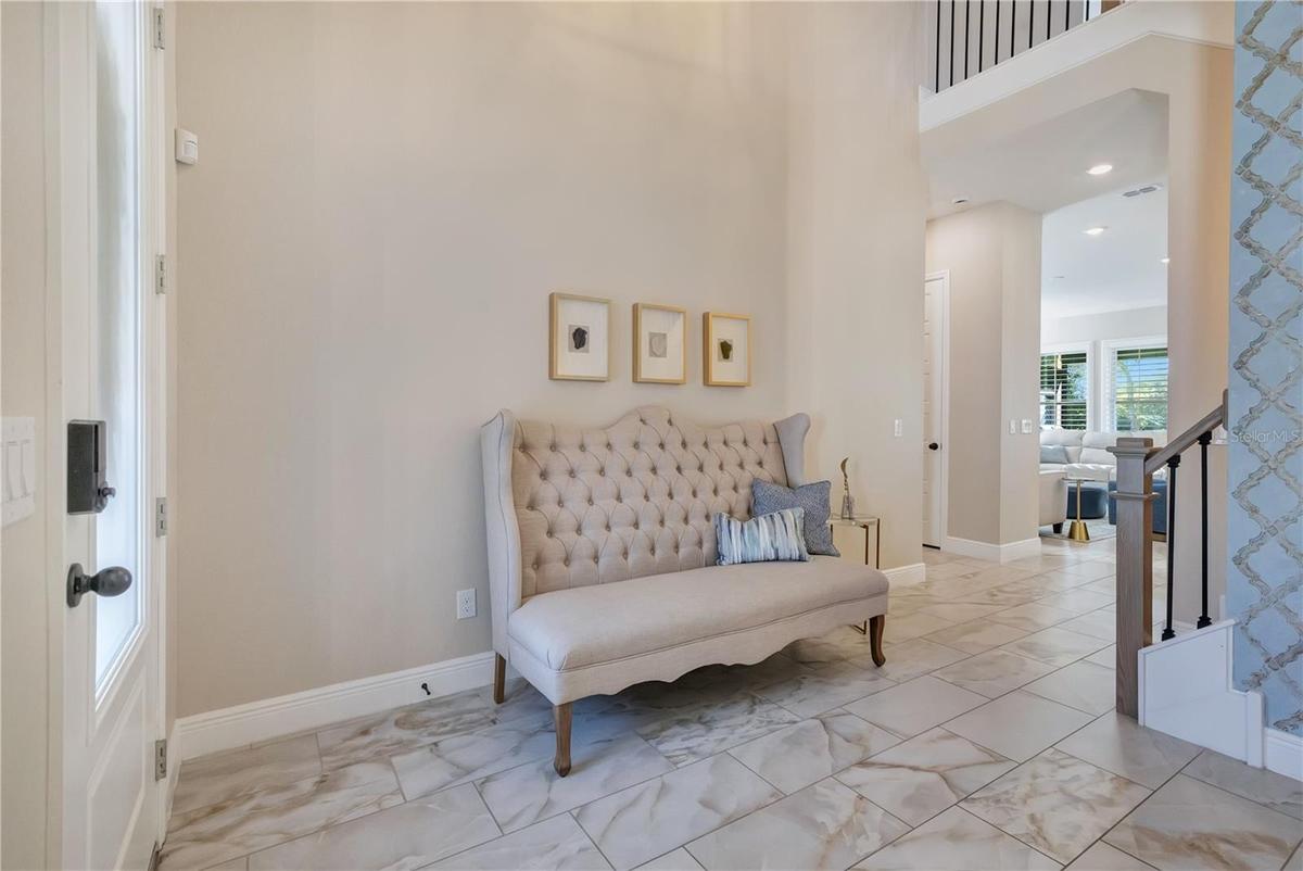 Bright foyer with soaring ceilings and upgraded tile flooring creates an inviting first impression.
