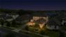 Angled twilight aerial highlights the home’s exterior lighting and scenic surroundings.