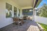 Covered outdoor dining area with a custom summer kitchen, built-in grill and beverage refrigerator.