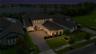 Twilight aerial showcases the home with the lake visible beyond the surrounding trees.