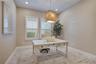 Dedicated office featuring plantation shutters, recessed lighting and a decorative pendant fixture.