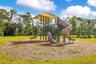 Community playground featuring climbing structures and slides in an open grassy setting.
