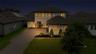 Elevated evening view highlights the front entrance, driveway and landscape lighting.