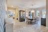 Elegant dining room featuring a statement chandelier, crown molding and upgraded tile flooring.