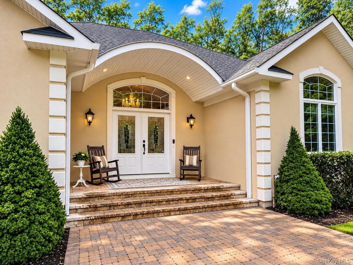 Elgant covered entry with stoen walkways leading from driveway