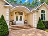 Elgant covered entry with stoen walkways leading from driveway
