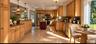 AI Enhanced Photo: Kitchen featuring warm-toned wood cabinetry, dark stone countertops, a central island with a contrasting finish, stainless steel ap