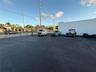 Asphalt-paved surface area with perimeter chain-link fencing and a solid masonry exterior wall