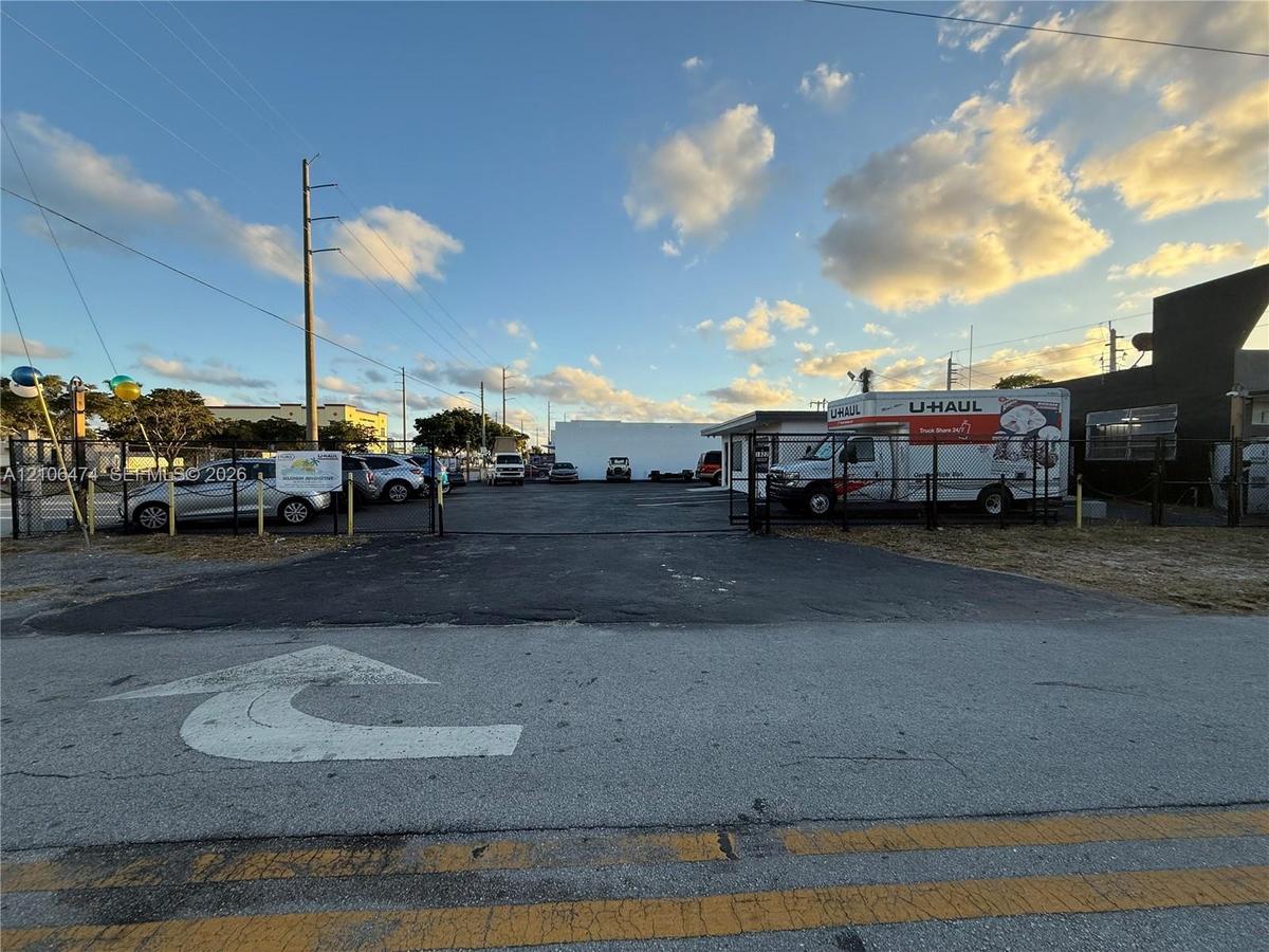 Paved open-air lot featuring a chain-link perimeter fence and gated access