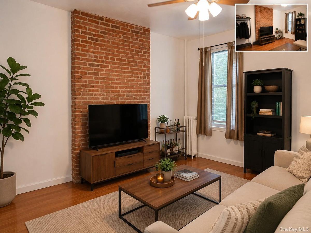 Exposed brick accent wall with wood-finish flooring, ceiling fan, and window with natural light (virtually staged)