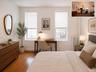 Room featuring two windows with white blinds, wood-finish flooring, and a built-in radiator (virtually staged)