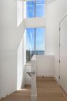 Full-height floor-to-ceiling windows, wood-finish flooring, solid-surface handrail, and minimalist interior architecture