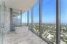 Floor-to-ceiling windows, freestanding soaking tub, stone-finish wall cladding, stone-finish flooring, and glass-enclosed shower