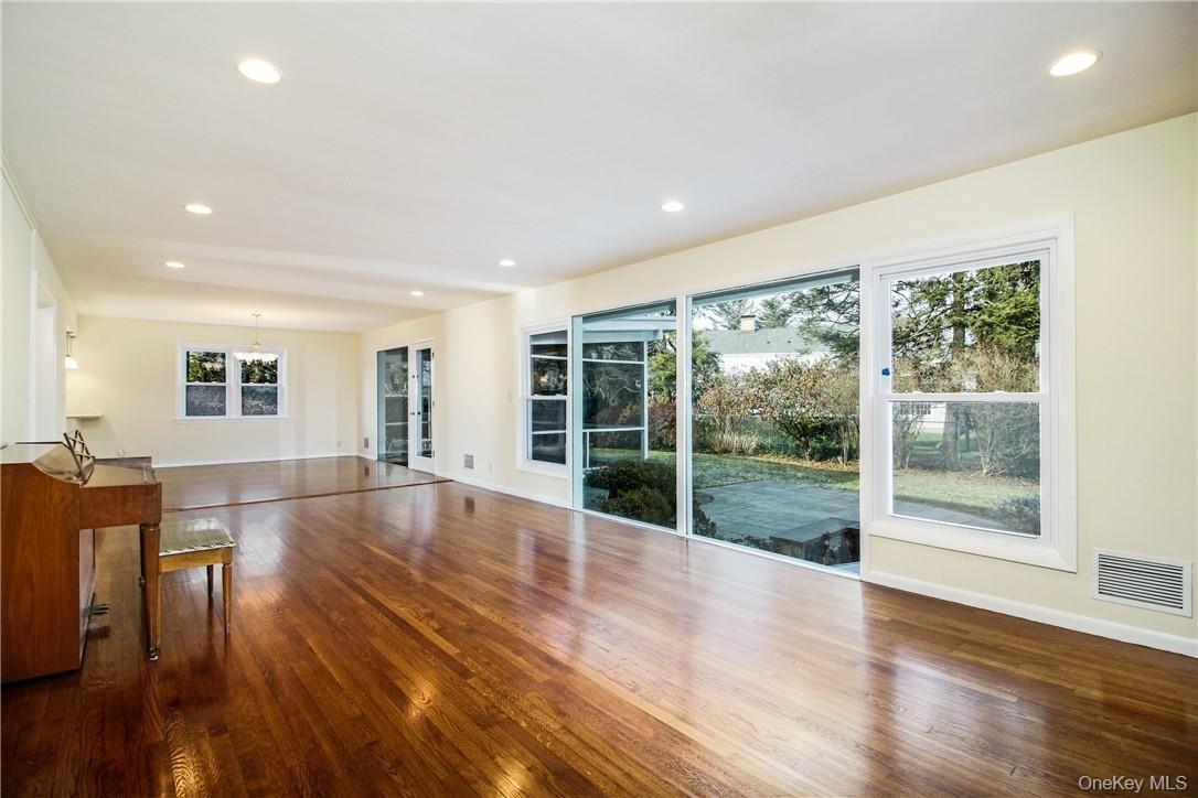 View of great room facing dining area and covered screened porch. Photos taken when house was empty prior to occupancy.