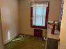 Carpeted spare room featuring baseboards and radiator heating unit