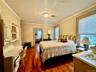 Bedroom with ornamental molding and dark wood-type flooring