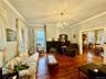 Living room with ornamental molding, a chandelier, and wood-type flooring
