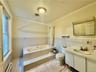 2nd floor Full bathroom with a baseboard radiator, tile walls, toilet, vanity, and tile patterned flooring