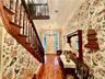 Foyer entrance featuring crown molding, a notable chandelier, and hardwood / wood-style floors