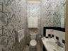 1st floor Bathroom featuring toilet, tile patterned flooring, ornamental molding, sink, and tile walls