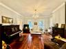 Living room featuring crown molding, a notable chandelier, and wood-type flooring