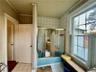 Bathroom with tile patterned floors, combined bath / shower with glass door, and ornamental molding