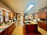 Kitchen featuring stainless steel appliances, sink, a center island, light wood-type flooring, and a skylight