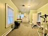 Workout area featuring ornamental molding, light carpet, and a baseboard radiator
