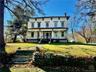 Italianate house featuring a porch and a front lawn