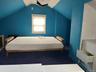 Bedroom with vaulted ceiling and radiator heating unit