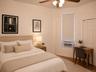 Bedroom featuring a ceiling fan with integrated lighting, wood-finish flooring, and a window with a roller blind (virtually staged)