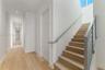 Staircase featuring wood-finish treads, metal handrails, and vertical metal balusters, complemented by recessed ceiling lighting and wood-finish floor
